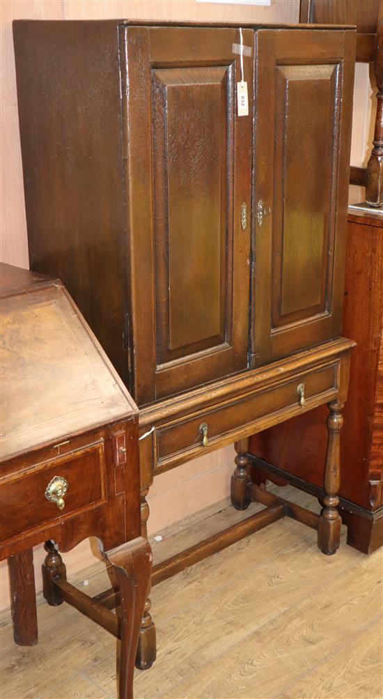 A 19th century oak two-door cupboard on later stand W.80cm